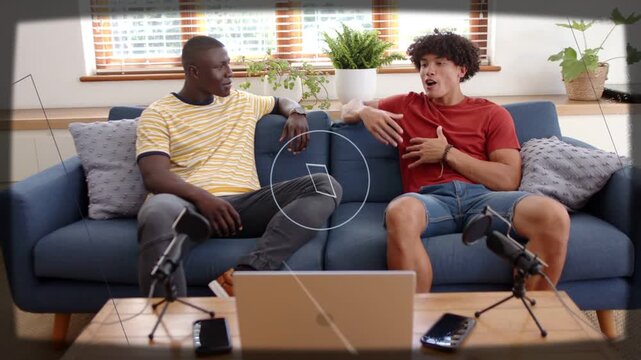 Starting recording, co-hosts in red, yellow striped tees gesturing on blue sofa with laptop mics