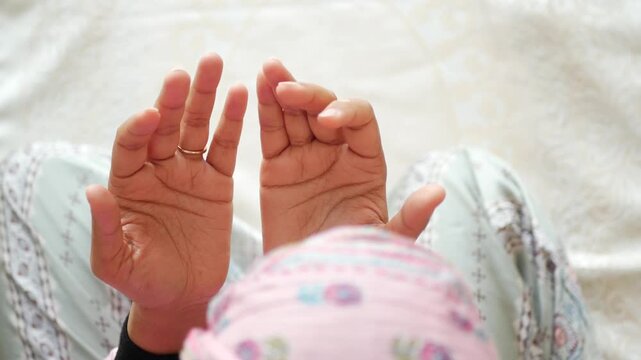 Close up of hands praying, devotional moment, cultural ritual, serene spiritual practice.