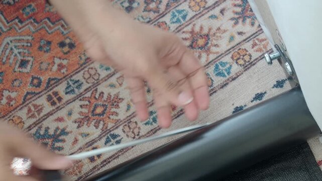 Woman using hex key to assemble furniture, close up shot of hands, diy home improvement.