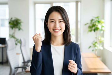 Obraz premium オフィスでガッツポーズをして笑顔を見せる日本人女性のビジネスパーソン Generative AI