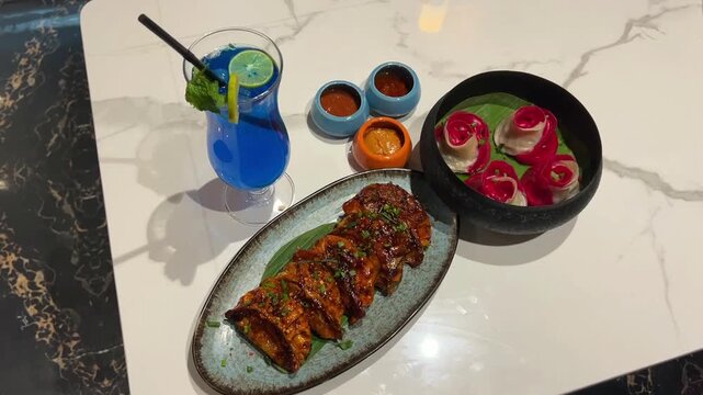 Rose momo and schezwan momo served with blue lagoon drink in Indian restaurant