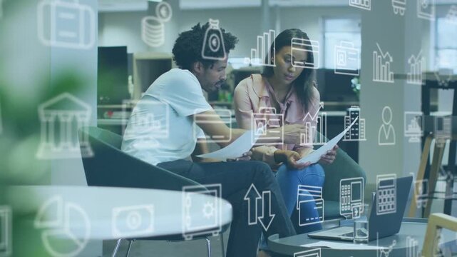 Leaning man showing pages to woman pink-top pointing at laptop office reviewing data overlay icons