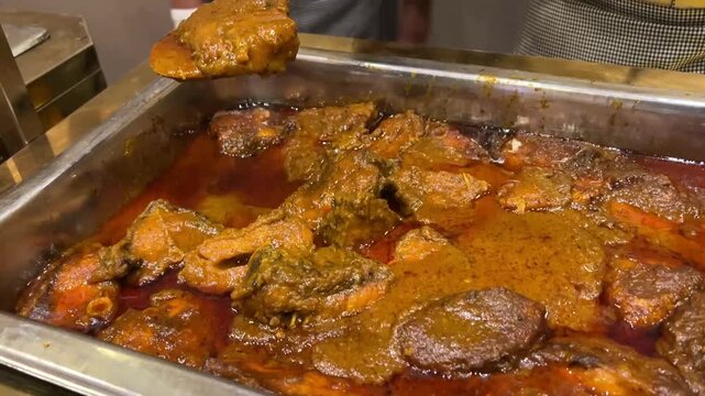 Indian-style Katla fish curry; a popular traditional seafood dish from West Bengal, prepared with authentic ground spices and served in a decorative bowl.