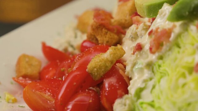 close up of a salad with bacon bits and avocado