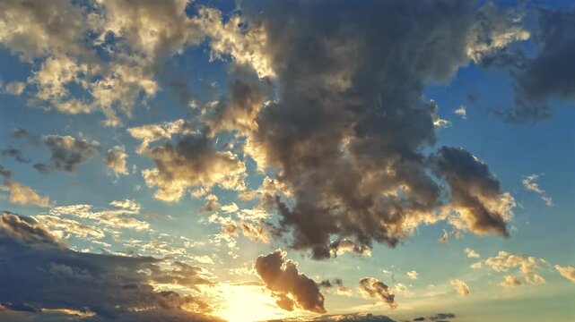 A hyperlapse sequence capturing the richly layered sky at dusk. Luminous orange and gold-rimmed clouds drift across a deep cobalt blue sky as the last light of day edges them in warm amber. 