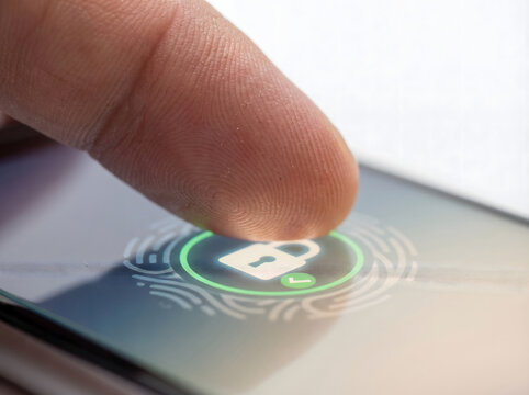 Close-up of a human finger activating biometric fingerprint authentication on a smartphone screen, illustrating secure digital access and advanced data protection technology