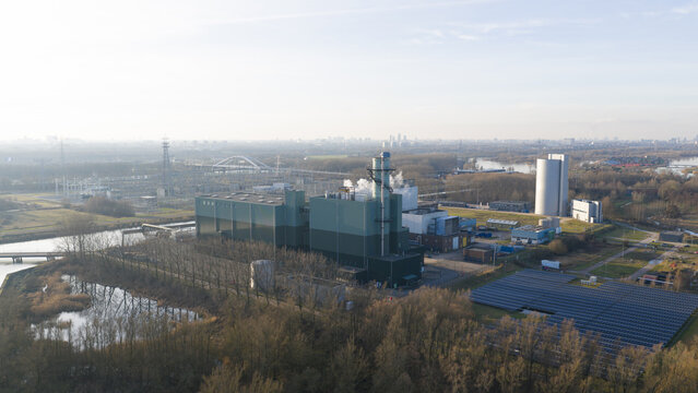 Aerial view of the Vattenfall Elektriciteitscentrale Diemen power plant with solar panels and industrial structures surrounded by trees and water in Diemen, Noord-Holland, Netherlands.