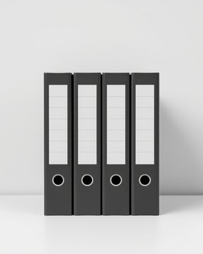 Four black binders with silver rings on a gray background isolated on white background
