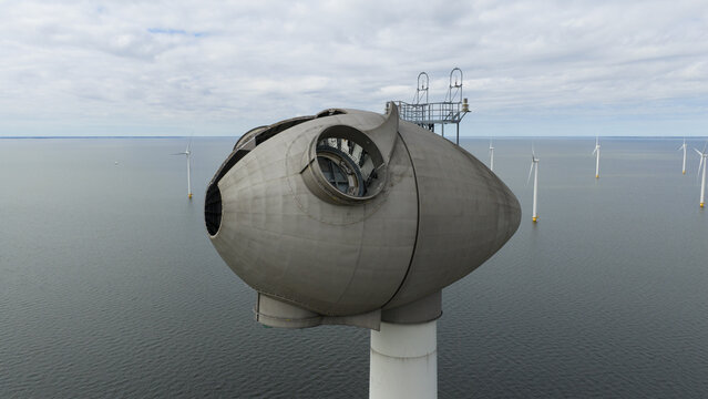 Aerial view of the Westermeerdijk wind farm nacelle without blades showing the internal hub mechanism over the water in Espel, Flevoland, Netherlands.