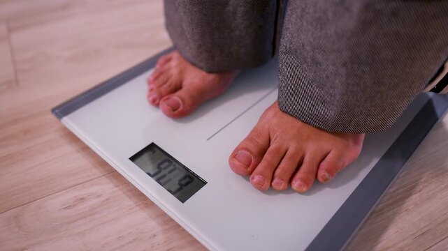 Bare Feet Stepping onto a Digital Bathroom Scale for Weight Measurement