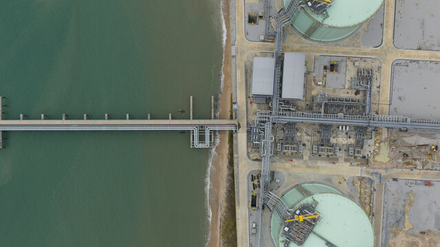 Aerial view of PTTLNG Nong Fab LMPT2 terminal featuring large storage tanks and industrial piping along the coast in Tambon Map Ta Phut, Chang Wat Rayong, Thailand.