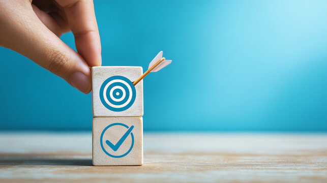 hand pushing wooden blocks with a checkmark icon towards a goal target on a blue background.