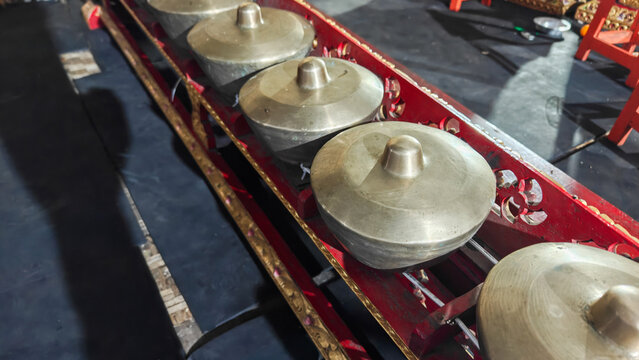 Traditional Indonesian Gamelan Percussion Instruments Bonang Barung on Red Wooden Frame