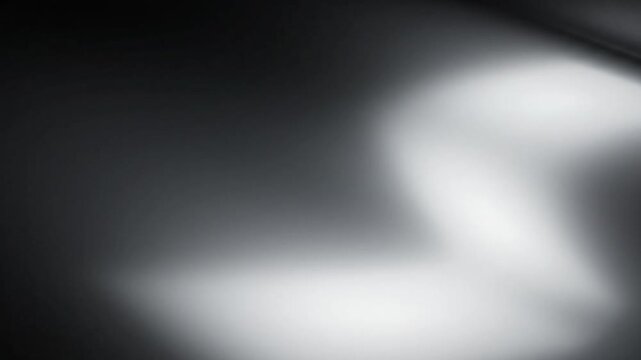 Abstract dark metallic surface with smooth flowing highlights and shadows creating a sophisticated modern background