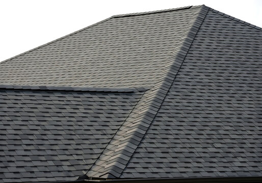 Modern residential roof with dark gray shingles in good condition