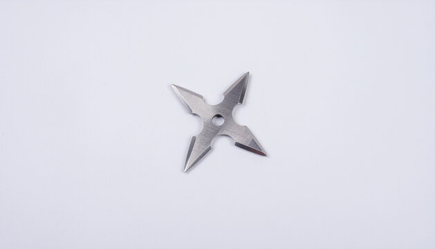 Silver metal ninja shuriken throwing star isolated on a white background