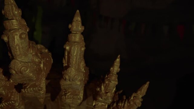 Low light panning left to right of a Naga multi-headed ornament inside a cave in Laos