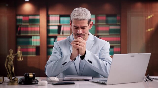 Lawyer Praying Thoughtfully At Desk