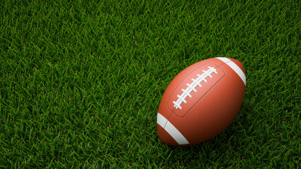 Obraz premium American football ball on a green grass field background