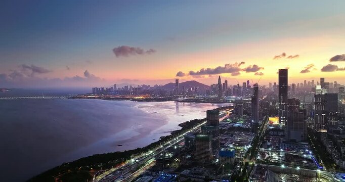 Aerial view of modern Shenzhen city skyline and coastal bay area at sunset, China