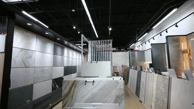 Element of Modern tile showroom interior with large ceramic and porcelain slabs displayed in vertical racks. Wide view shot