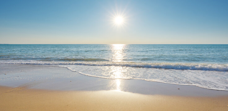 Bright Sun Over Tropical Sandy Beach With Calm Sea Waves And Ocean Horizon.