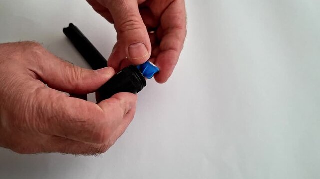 Disassembled flashlight parts displayed on white surface with hand above, showing body, bulb, and end cap components during assembly, repair, or product demonstration process