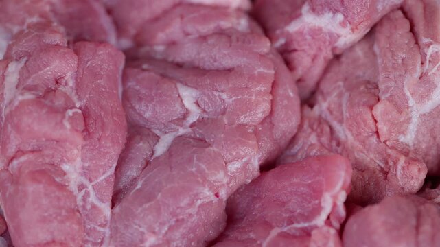 Detailed view of juicy raw pork showcasing marbling and moisture levels. Photograph capturing fresh uncooked pork highlighting intricate marbling patterns and natural juices