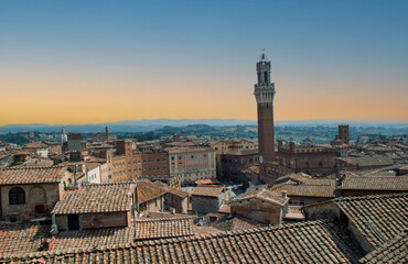 Obraz premium This image depicts a panoramic view from above of the Piazza del Campo in Siena, with the distinctive Torre del Mangia dominating the cityscape.