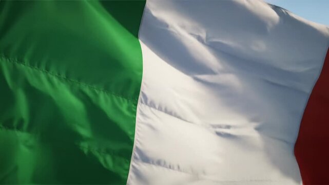 An elegant high-angle ecu video of the vibrant italian national flag. rich green, white, red stripes fill the frame, softly undulating with diffused daylight, highlighting texture. concept of