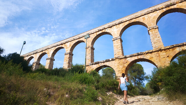 Woman hiking ancient Roman aqueduct in Tarragona Spain