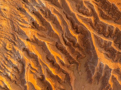 Aerial view of intricate sandstone formations and eroded hoodoos with orange and brown layers at Goblin Valley State Park in Green River, Utah, United States.