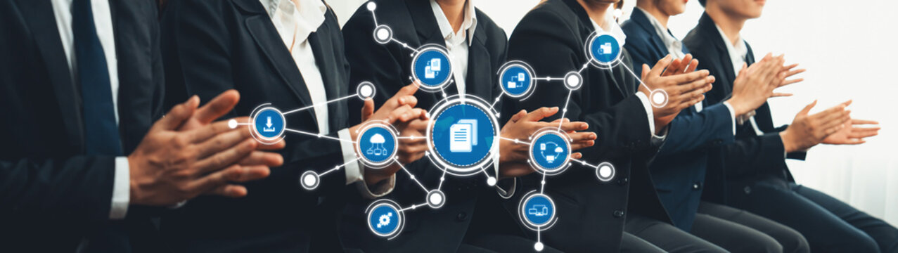 A professional business team claps in appreciation while a digital network of icons symbolizing management concepts and innovations is displayed in the foreground. Amity