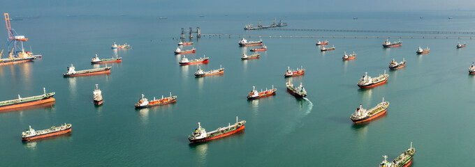 Aerial view of numerous oil and gas tankers anchored in a bay, showcasing large-scale maritime energy transport and dense commercial sea traffic. © Sunday Stock