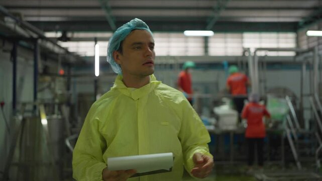 Workplace Inspection: An individual in protective attire meticulously inspects a food processing facility, symbolizing adherence to stringent hygiene standards and operational efficiency. 