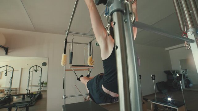 Determined woman exercising on a pilates cadillac reformer machine