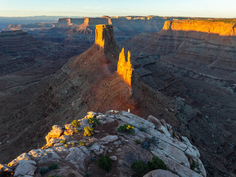 Aerial view of Canyonlands National Park with towering red rock buttes and deep canyons under golden hour light Utah, United States.