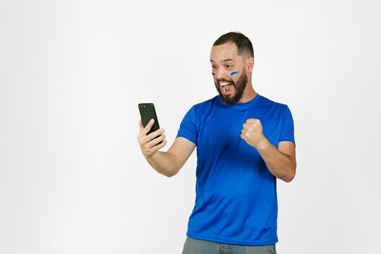 Soccer fan watching game on smartphone celebrating goal