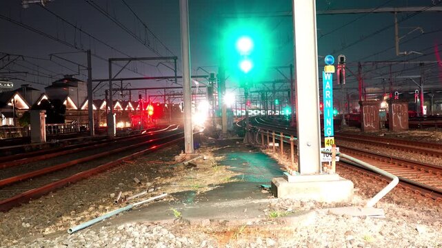 Night time lapse of multiple trains passing in both directions with changing signals on busy urban rail corridor in Sydney