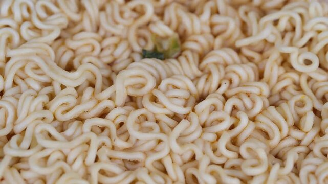 Food texture highlight. Closeup of ramen noodles details. Detailed shot capturing dry curly ramen strands. Macro image emphasizing noodle texture and subtle seasoning