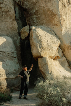 ginger man with tattoos in joshua tree rocks at golden hour