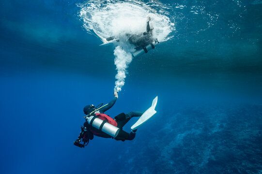 Diver teasing friend with air bubbles in the southern Maldives