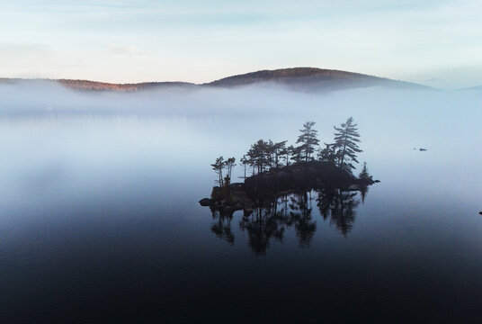 Isolated island in morning fog and mist on a lake in Maine