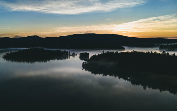Spring morning over a lake with islands in Maine with low mist