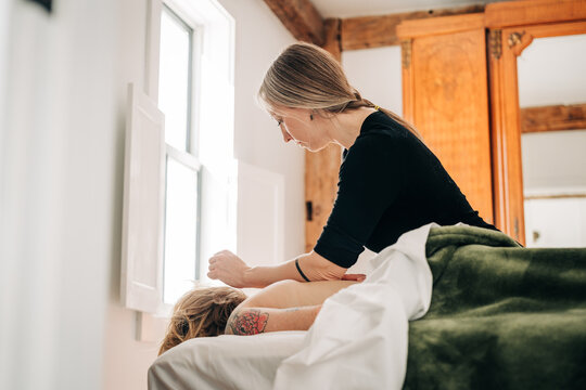 Woman performing deep tissue massage on customer