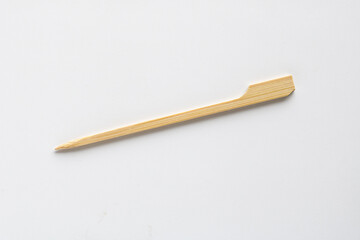 Naklejka premium A wooden food stick on a white background, showing pointed tips and smooth texture.