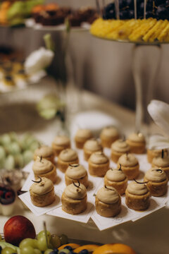 Dessert buffet table serving sweet mini cakes and fresh fruit