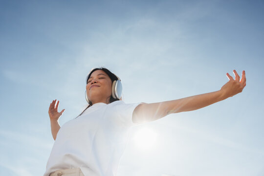 Woman with headphones enjoying outdoor music and relaxation