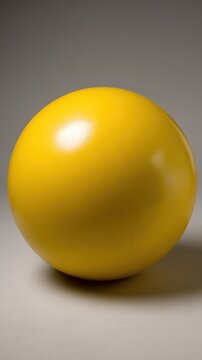 Bright yellow sphere on neutral background with smooth surface texture