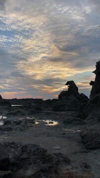 Vertical 4K sunset at Godzilla Rock in Oga Peninsula, Akita Japan, famous rock silhouette with beautiful golden hour colors
